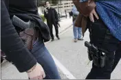  ?? ERICH SCHLEGEL — GETTY IMAGES/TNS ?? Two women compare handgun holsters during an open carry rally at the Texas State Capitol in Austin, Texas.