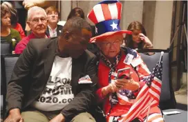  ?? (Carlo Allegri/Reuters) ?? PEOPLE LOOK at results on a phone at Republican Senate candidate Roy Moore’s election night party in Montgomery on Tuesday.