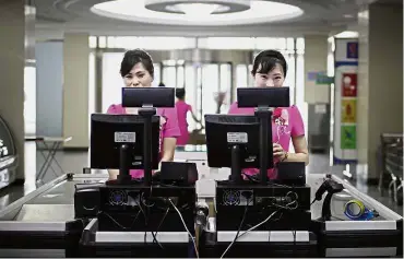  ?? — AP ?? Check it out: Cashiers waiting to serve customers at the Potonggang department store in Pyongyang.