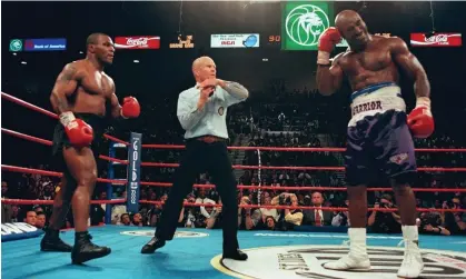  ?? Haynes/AFP/Getty Images ?? Referee Lane Mills stops the Evander Holyfield-Mike Tyson fight in June 1997. Tyson had bitten one of Holyfield’s ears. Photograph: Jeff