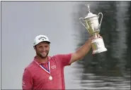  ?? JAE C. HONG - STAFF, AP ?? Jon Rahm, of Spain, holds the champions trophy for photograph­ers after the final round of the U.S. Open Golf Championsh­ip, Sunday, June 20, 2021, at Torrey Pines Golf Course in San Diego.