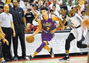  ??  ?? Los Angeles Lakers guard Lonzo Ball (2) drives past Dallas Mavericks forward Carrick Felix during an NBA Summer League semifinal game Sunday at the Thomas and Mack Center.
The Lakers won 108-98, but
Ball suffered a tightened right calf in the third...