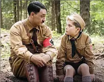  ?? The Associated Press ?? Taika Waititi, left and Roman Griffin Davis are pictured in a scene from “JoJo Rabbit,” now playing at Landmark Cinemas 7 and nominated for six Academy Awards, including best picture.