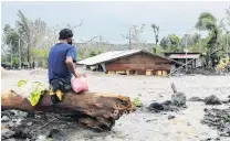  ?? PHOTO: REUTERS ?? Inundated . . . A man looks at his house buried under the pile of rubble and sand after floods brought by Typhoon Goni in Daraga town, Albay province, in the Philippine­s.