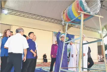  ??  ?? Dr Annuar strikes the ‘bedok’ to mark the start of the breaking of fast.