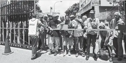  ?? CARLOS BECERRA BLOOMBERG ?? People wait for free soup outside a church in Caracas, Venezuela. Food, money and medicine are in increasing­ly short supply, yet the government refuses to open the country to aid to help desperate citizens.