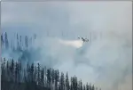  ?? Associated Press photo ?? In this photo taken Sunday, an air tanker drops water over a wildfire burning in Glacier National Park, Mont.