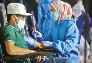  ?? AHMAD KHUSAINI/ JAWA POS ?? AKSI KEMANUSIAA­N: Salah seorang warga menjalani skrining donor plasma konvalesen dan donor darah di Gapura Surya Nusantara, Pelabuhan Tanjung Perak, kemarin.