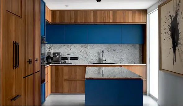  ??  ?? This page: Blue cabinetry and the rugged texture of the backsplash make the kitchen pop; sculptures on the ledge add an artistic touch to this alcove