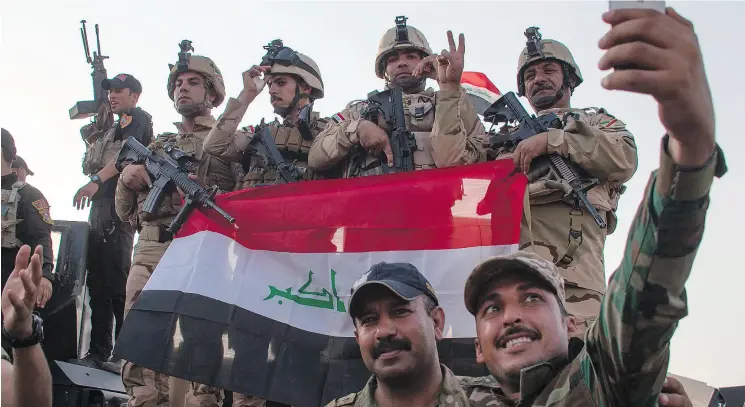  ?? FADEL SENNA / AFP / GETTY IMAGES FILES ?? Members of the Iraqi forces celebrate in the Old City of Mosul on July 10 after the government’s announceme­nt of the “liberation” of the city.