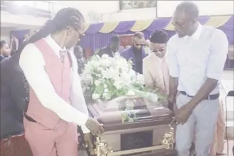  ??  ?? Usain Bolt (right) helps carry the coffin of friend and Olympian Germaine Mason.