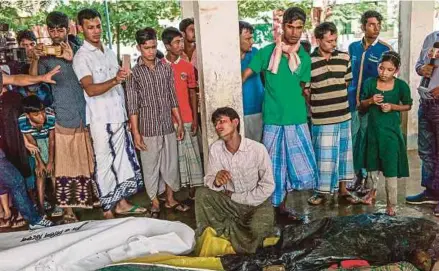  ??  ?? Seorang pelarian Muslim Rohingya menangis selepas mengenali mayat isterinya yang terkorban dalam insiden bot karam di pantai Inani di Cox’s Bazar, semalam.