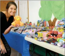  ?? TIMES photograph by Annette Beard ?? Morgan Guyll, of Pea Ridge, an ambassador for Arkansas Children’s Hospital, shows off the more than 500 toys donated by children at Twelve Corners Baptist Church for children at ACH. The toys were donated as part of a competitio­n during Vacation Bible...