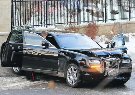  ?? GAVIN YOUNG ?? Police inspect a damaged Rolls-Royce in the community of Mount Royal after a gunman attacked real estate mogul Riaz Mamdani.