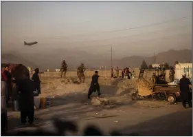  ?? (The New York Times/Jim Huylebroek) ?? People move around the northern perimeter of the airport in Kabul, Afghanista­n, on Tuesday despite warnings from the Taliban to stay away.