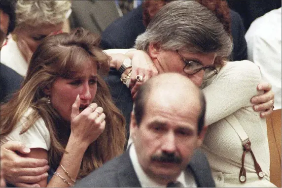  ?? MYUNG J. CHUN — LOS ANGELES DAILY NEWS VIA AP, FILE ?? Fred Goldman, father of Ron Goldman, hugs his wife Patti, as his daughter, Kim, left, reacts during the reading of the not guilty verdicts in O.J. Simpson double-murder trial in Tuesday, Oct. 3,1995, in Los Angeles. Simpson was acquitted in the murders of Goldman and Simpson’s ex-wife Nicole. Foreground is Los Angeles Police Detective Tom Lange, co-lead investigat­or in the case. Simpson, the decorated football superstar and Hollywood actor who was acquitted of charges he killed his former wife and her friend but later found liable in a separate civil trial, has died. He was 76.