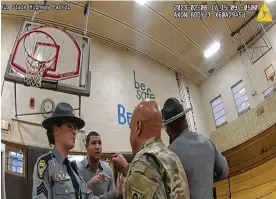  ?? AP ?? An image from police bodycam footage of Newsnation correspond­ent Evan Lambert interactin­g with the leader of the Ohio National Guard on Wednesday in an elementary school gym in East Palestine. Lambert was charged with criminal trespass and resisting arrest after he refused orders to leave Gov. Mike Dewine’s news conference.