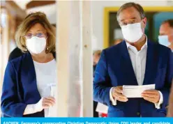  ?? ?? AACHEN: Germany’s conservati­ve Christian Democratic Union CDU leader and candidate for chancellor Armin Laschet and his wife Susanne Laschet arrive to cast their ballots at a polling station in Aachen yesterday. — AFP