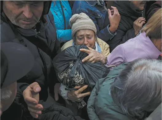  ?? Reuters / Gleb Garanich ?? A resident of Balakliia, Ukraine, collects a bag containing humanitari­an aid as help arrived in the newly liberated city this week.