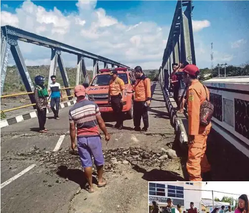  ?? AGENCY PIX ?? Search-and-rescue personnel examining a damaged road after a 6.4-magnitude earthquake struck Lombok yesterday. (Inset) A woman attending to an injured person outside a hospital in Sembalun Selong village, Lombok.