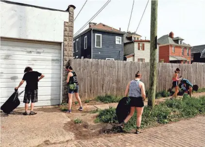  ?? FRED SQUILLANTE/ COLUMBUS DISPATCH ?? Members of the Ohio Roller Derby league were among about 15 volunteers who joined a cleanup Saturday, organized by the nonprofit volunteer group Green Columbus as part of its Earth Day Columbus effort.