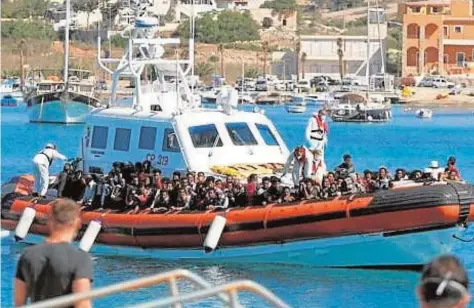 ?? REUTERS ?? Un barco de búsqueda y rescate acerca a tierra a los inmigrante­s que han llegado a Lampedusa