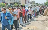  ?? PTI ?? People wait in a long queue to buy liquor from a wine shop after the ease in the ongoing lockdown restrictio­ns in Jammu on Wednesday. Policemen were deployed outside wine shops to maintain order and ensure adherence of Covid-19 guidelines. —