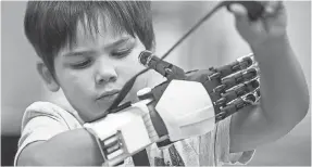  ?? SEAN LOGAN/THE ARIZONA REPUBLIC ?? Jacob Taggart tests his prosthetic hand.