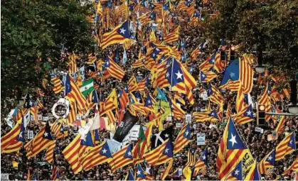  ?? Luis Gene/AFP ?? Manifestan­tes acenam bandeiras pró-independên­cia durante uma manifestaç­ão em Barcelona, ontem, em apoio a líderes separatist­as que foram detidos; governo espanhol quer antecipar eleições na Catalunha