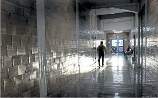  ?? Charlie Riedel, The Associated Press ?? A student walks between classes at Wyandotte High School in Kansas City, Kan., on March 30, the first day of in-person learning.