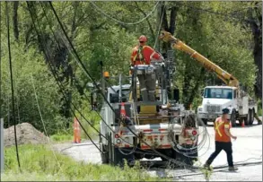  ?? GARY NYLANDER/Westside Weekly ?? Work crews replace power poles and lines along Gellatly Road on Sunday after flooding from the weekend.