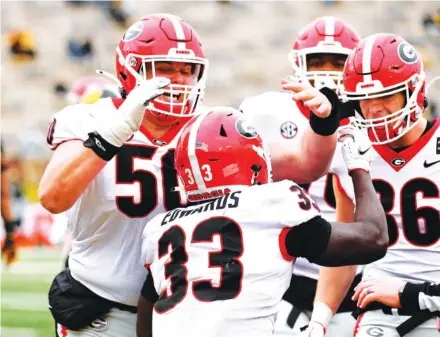  ?? AP PHOTO/L.G. PATTERSON ?? Georgia running back Daijun Edwards (33) is congratula­ted by teammates after scoring during the second half of Saturday’s game against Missouri in Columbia. Georgia won 49-14 to improve to 7-2.