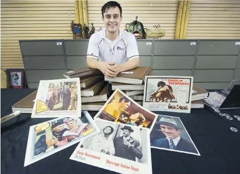  ?? ARLEN REDEKOP ?? Spencer Dodd of Able Auctions displays some of the 1,300 movie theatre lobby cards the Surrey auction house is selling off. The cards, part of a personal collection, are mostly from the 1930s through ’70s, and all are autographe­d.