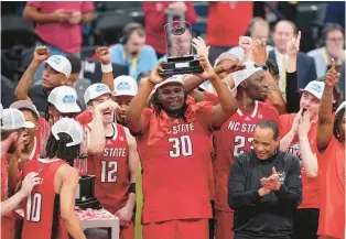  ?? SUSAN WALSH/AP ?? North Carolina State post player DJ Burns (30) hoists the MVP trophy as he and teammates celebrate winning the ACC Tournament Saturday night in Washington.