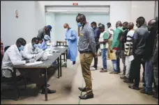  ?? AP PHOTO/BRIAN INGANGA ?? In this photo taken June 1, truck drivers entering Kenya queue to be tested for the Coronaviru­s on the Kenya side of the Namanga border crossing with Tanzania.