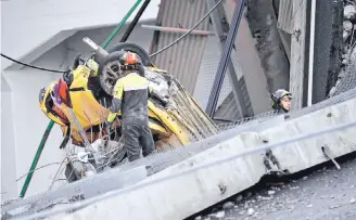  ?? |AP ?? El miércoles continuaba­n los esfuerzos de bomberos y rescatista­s entre los restos del puente y de los vehículos que cayeron al vacío tras el desplome