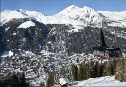  ?? AP PHOTO/MICHEL EULER ?? A cable car makes its way to the Jakobshorn mountain Friday on the fourth day of the annual meeting of the World Economic Forum in Davos, Switzerlan­d.