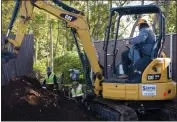  ?? ?? Left to right, Santos Excavating employees Brandon Braty, Angel Orozco and Humberto Orozoco in the excavator work together on grading and undergroun­d work Wednesday for the Everhart Village emergency shelter project in Chico.