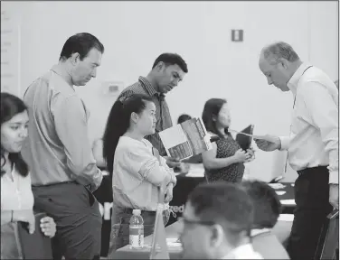  ?? AP/MARCIO JOSE SANCHEZ ?? Phil Wiggett (right), a recruiter with the Silicon Valley Community Foundation, looks at a resume Aug. 24 during a job fair in San Jose, Calif.