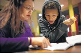  ?? Marie D. De Jesús / Houston Chronicle ?? Nicole Rechner, 33, looks over a math quiz with her son, Demarcus Fuller, 12, after dinner. Demarcus has performed much better since transferri­ng to Hamilton Middle School in March.