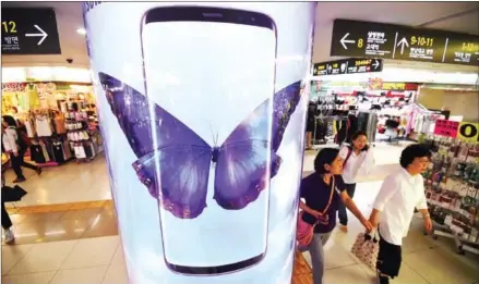  ?? JUNG YEON-JE ?? People walk past an advertisem­ent for the Samsung Galaxy S8 at a shopping mall in Seoul on Friday.