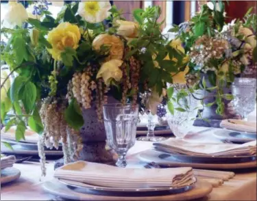  ?? DEAN FOSDICK VIA AP ?? This photo taken at the Comforts of Whidbey vineyard near Langley, Wash., shows a tablescapi­ng model that integrates natural elements with dinnerware, drinkware and other accessorie­s. Adding fresh flowers to the table is all about presentati­on — and...