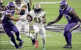  ?? Chris Graythen / Getty Images ?? Alvin Kamara (41) wore Christmas-themed shoes as he tied a 91-year-old mark with 6 rushing TDS. Minnesota was ousted from playoff contention.