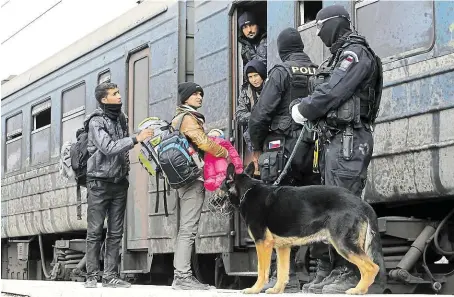  ?? Na snímku z února 2016 dohlíží na pořádek při odjezdu běženců do záchytného centra pro migranty u makedonské­ho města Gevgelija FOTO ČTK/ AP ?? Čeští policisté