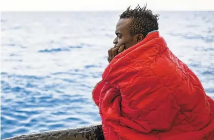  ?? AP PHOTO BY OLMO CALVO ?? A migrant rescued from a rubber dinghy off the Libyan coast looks at the sea from aboard the Open Arms aid boat Saturday.