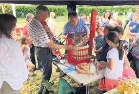  ??  ?? Star attraction Visitors were keen to see the apple-pressing demonstrat­ions
