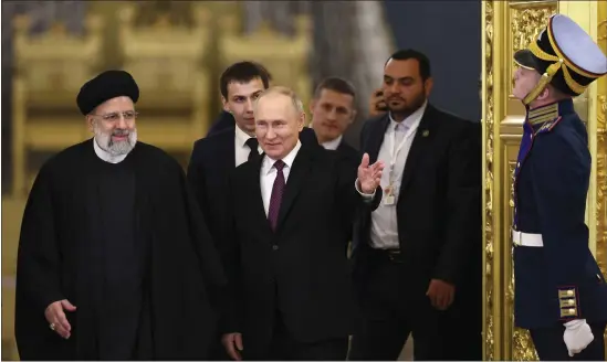  ?? SERGEI BOBYLEV, SPUTNIK, KREMLIN POOL PHOTO VIA AP ?? Russian President Vladimir Putin, center, welcomes Iranian President Ebrahim Raisi, left, for talks at the Kremlin in Moscow in December.
