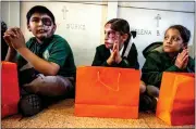  ?? ?? Our Lady of Guadalupe Elementary School students pray as they honor their departed.