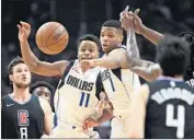  ?? Wally Skalij Los Angeles Times ?? MAVERICKS PLAYERS Yogi Ferrell (11) and Dennis Smith Jr. zero in on a loose ball.