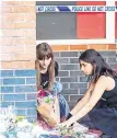  ??  ?? Two women lay flowers at the scene of Reading stabbings